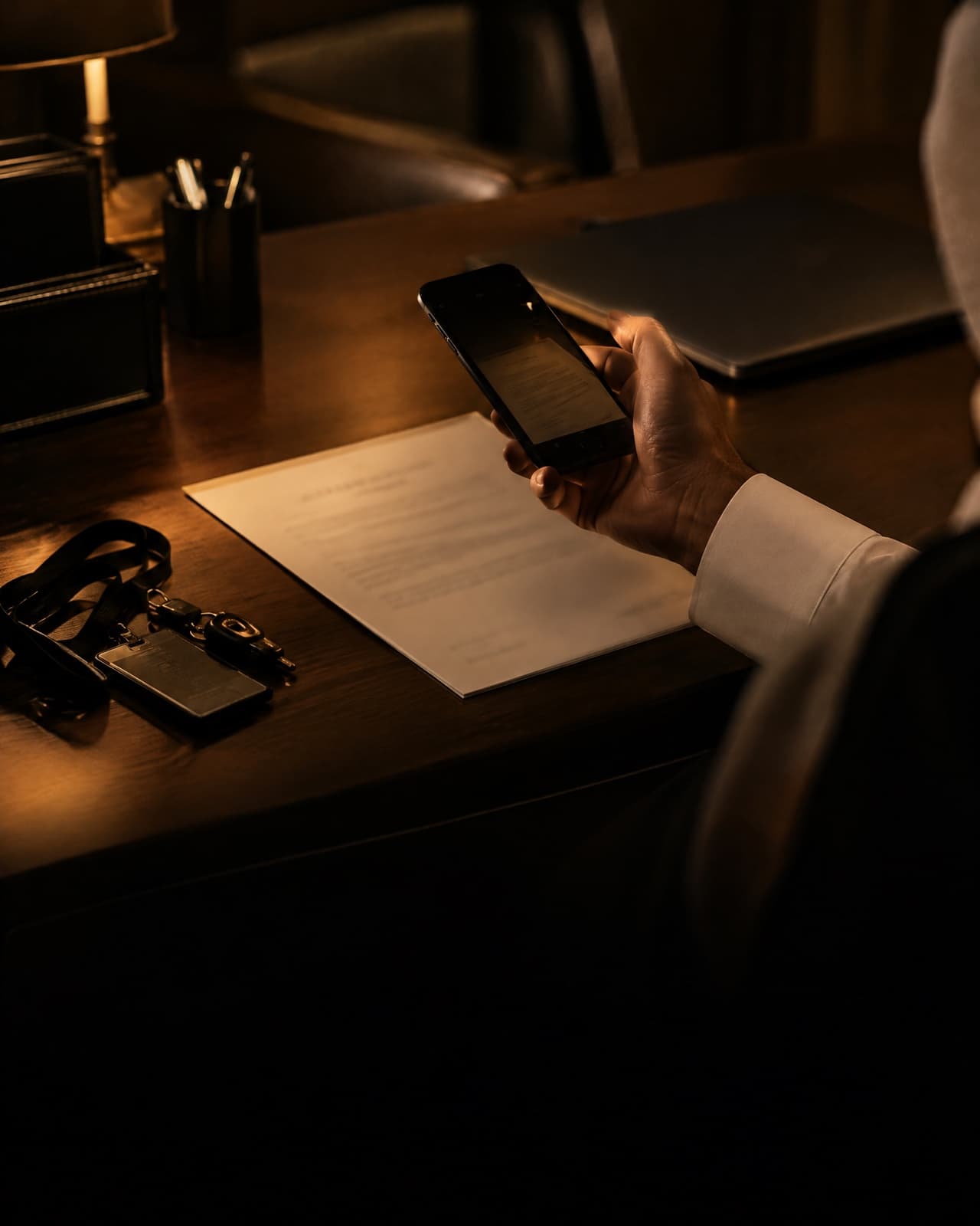 A hand taking a photo of a company letter on a kitchen counter with a phone.