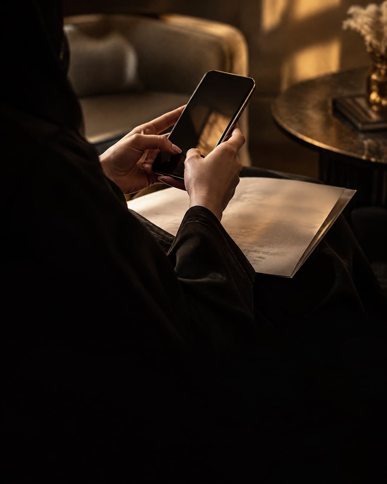 A hand photographing an official paper with a phone in a quiet waiting area.